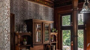 Une cuisine avec des meubles de couleur bois foncé, un plan de travail en marbre et une grande fenêtre.