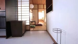 A traditional Japanese room with tatami flooring, a sliding door, and a low table. - GORAKU Shinfukae 201 (Osaka)