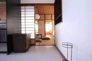 A traditional Japanese room with tatami flooring, a sliding door, and a low table. - GORAKU Shinfukae 201 (Osaka)