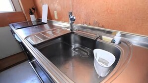 A kitchen with a stainless steel sink, a faucet, and a dish rack. - GORAKU Shinfukae 201 (Osaka)