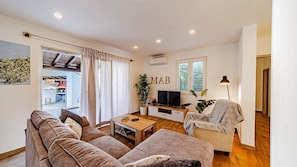A living room with a sofa, a coffee table, a TV, and a chair.