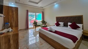 A hotel room with a large bed, a wooden wardrobe, a desk, and a chair. - Hotel New Snow Palace  (Dharamshala)