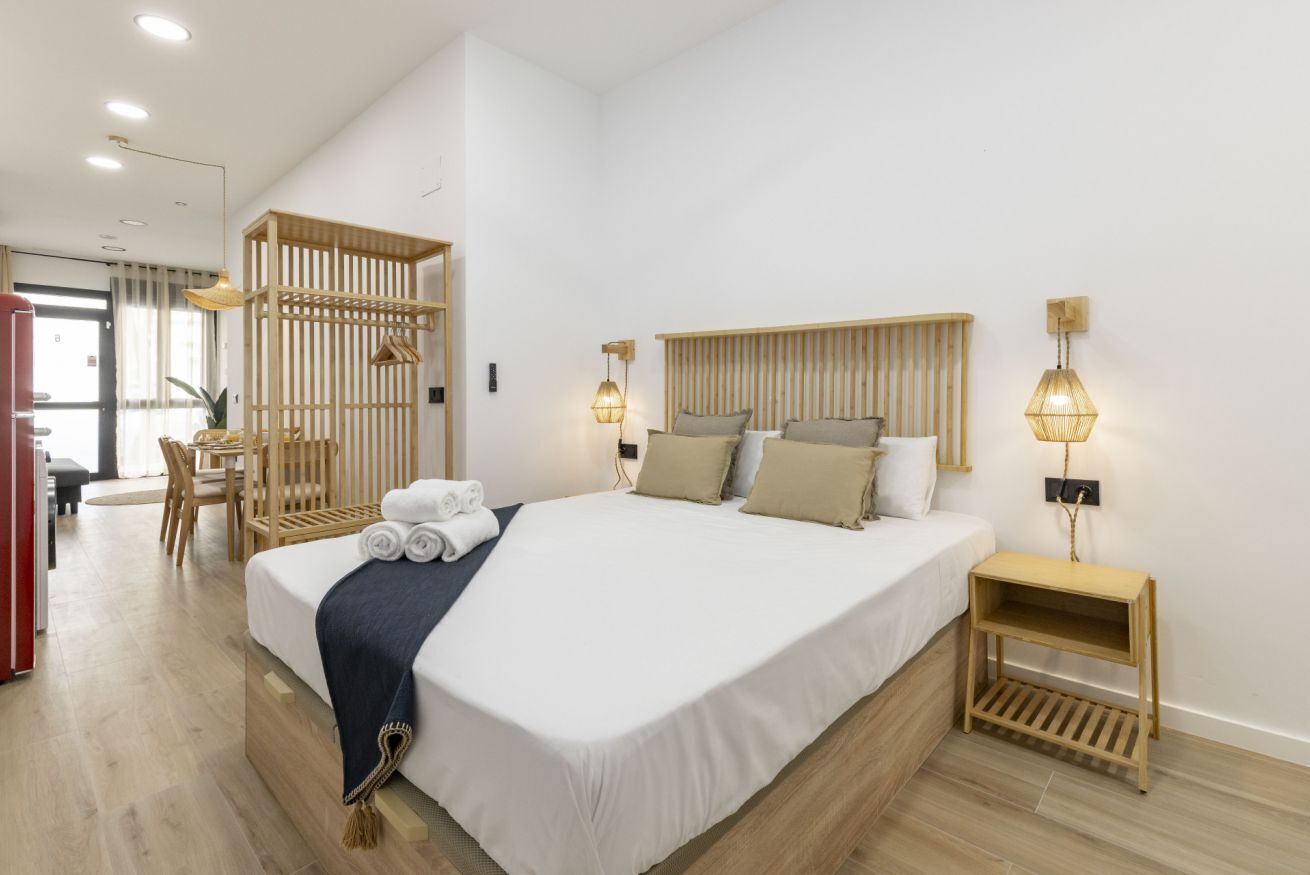 1 dormitorio y tabla de planchar con plancha