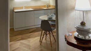 A modern kitchen with white cabinets, a microwave, and a dining area with a table and chairs. - La Dimora dei Tintori, elegant apartment in the center of Prato (Prato)