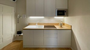 A compact kitchen with a white countertop, a built-in microwave, and a wooden cabinet. - La Dimora dei Tintori, elegant apartment in the center of Prato (Prato)