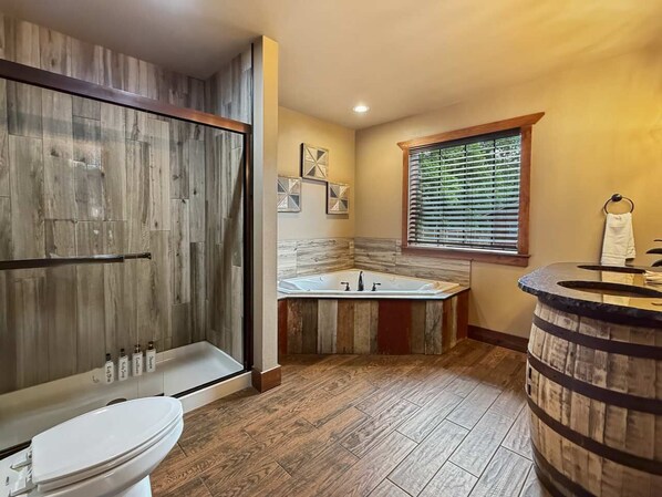 Une salle de bain avec une douche en bois, une baignoire, des toilettes et un lavabo en forme de tonneau en bois.