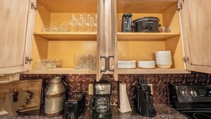 A kitchen with wooden cabinets, a coffee machine, a toaster, and a stove. - Sleeps 30 • Theater • Game Room • Big Cedar Area (Ridgedale)