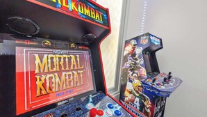 Une borne d’arcade du jeu Mortal Kombat, dotée d’un bouton de démarrage, d’un joystick et de boutons.