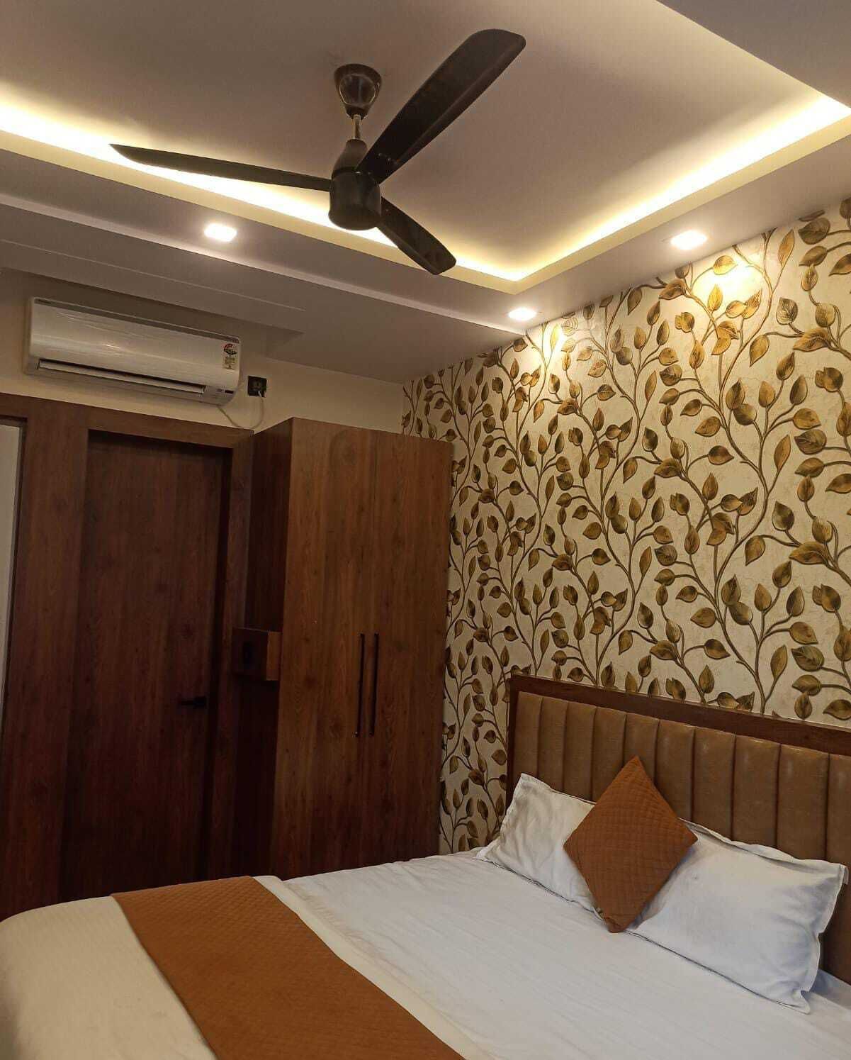 A bedroom with a bed, a ceiling fan, and an air conditioning unit.