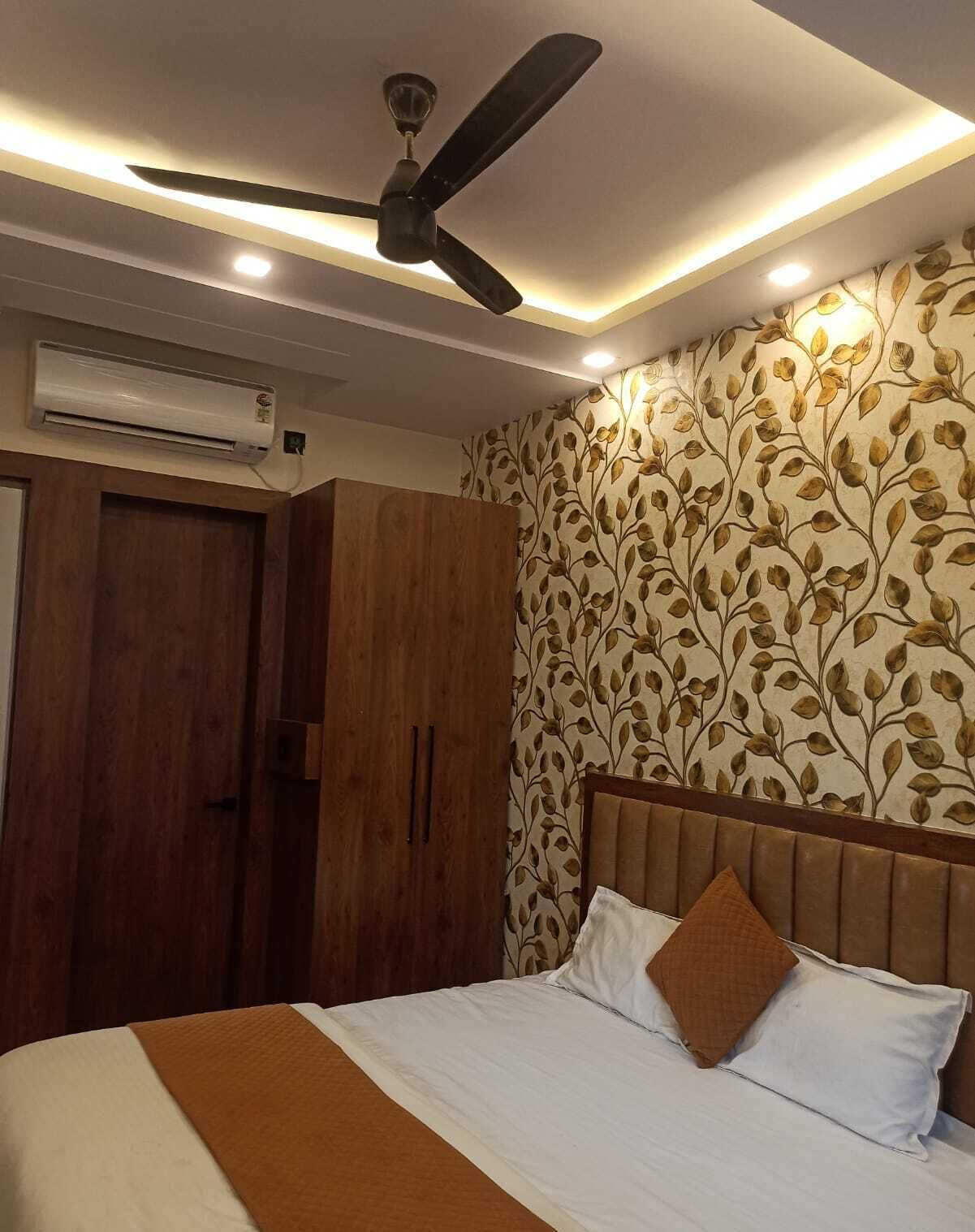 Un dormitorio con cama, ventilador de techo, unidad de aire acondicionado y armario.