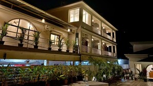 A multi-story hotel with balconies and potted plants. - Zuna Stayz Morjim Goa (Morjim)