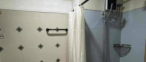 A small bathroom with a toilet, a shower, and a sink.