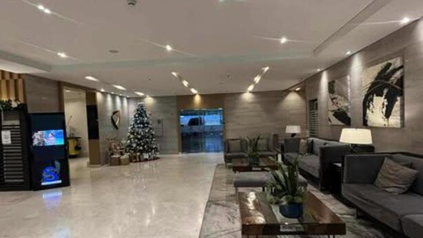 Eine großzügige Lobby mit modernem Design, inklusive eines großen Weihnachtsbaums, gemütlichen Sitzbereichen und einer Rezeption.