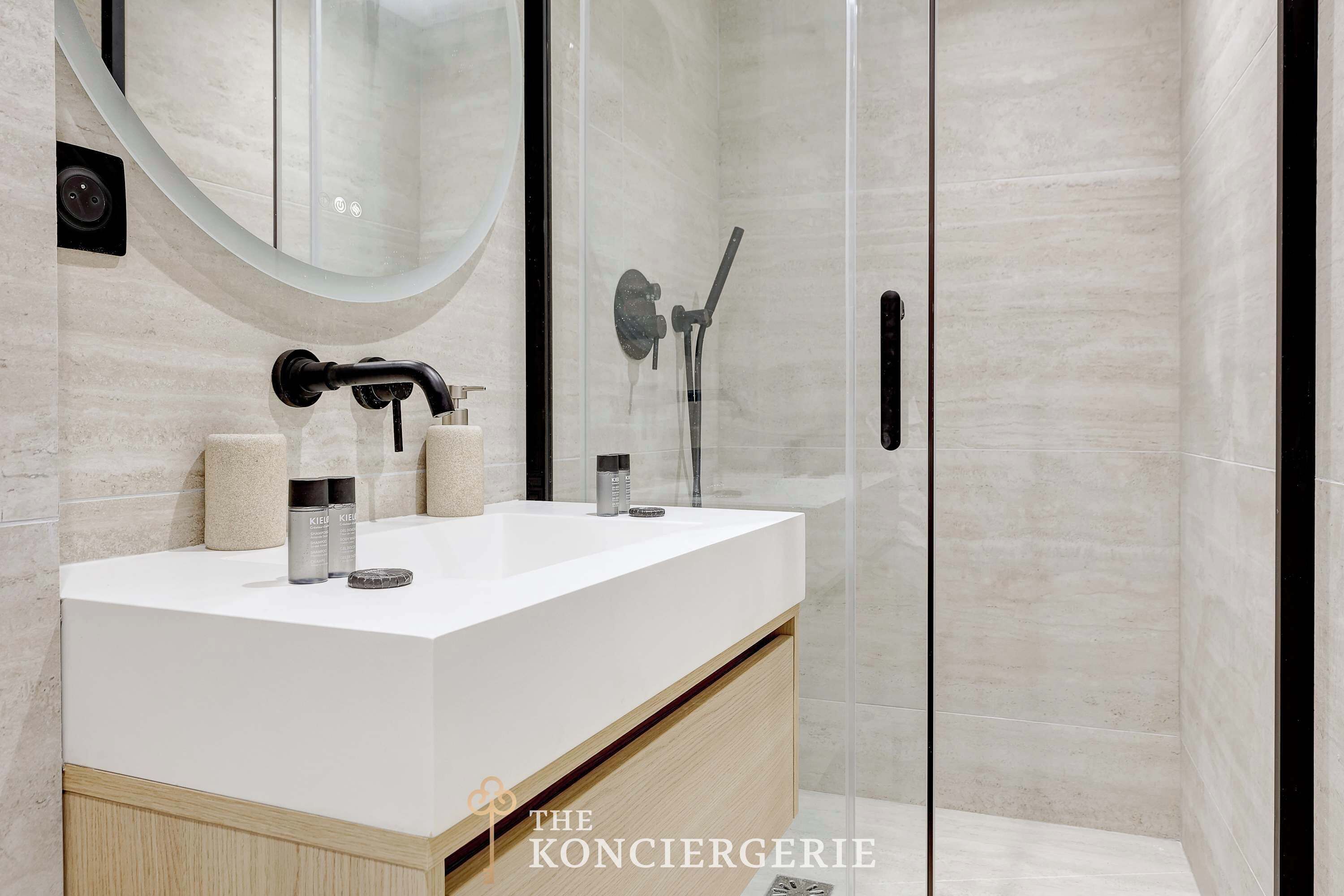 Une salle de bain moderne avec un meuble-lavabo blanc, une cabine de douche en verre et un grand miroir.