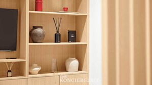 Une étagère en bois ornée de divers objets décoratifs, un téléviseur et un livre.