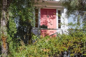 Una casa con una puerta rosa y un cartel con el número 2255.
