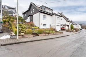 A residential street with houses, a sidewalk, and a road. - Richter Apartment with Mountain View and Shared Terrace (Kirchhundem)