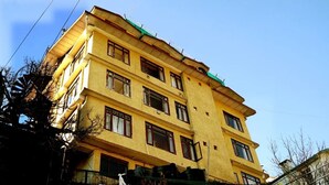 A multi-story yellow building with a flat roof and multiple windows. - Harmony Sentiments-The Mall Road (Shimla)