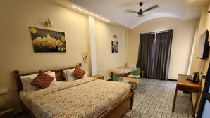 A bedroom with a bed, bedside tables, a desk, and a chair. - JHAR ARRAVLI RESORT  (Bassi)