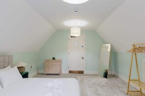 A bedroom with a bed, dresser, mirror, and a wooden ladder. - Spacious 3BD Flat in Historic Building Shoreditch (Greater London)