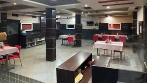 Ein geräumiges Restaurant mit hohen Decken, mehreren Essbereichen und moderner Einrichtung.