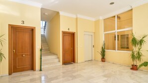 Un couloir avec deux portes en bois, numérotées 3 et 4, qui donnent sur un escalier.