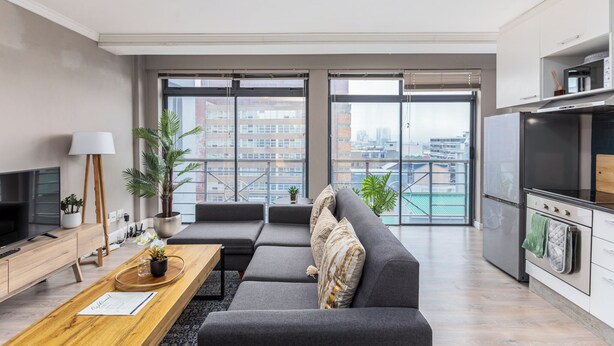 A modern apartment with a living area, kitchen, and large windows offering a city view. - The Square 513 by CTHA (Cape Town)