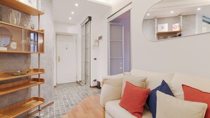 Una sala de estar moderna con un sofá, almohadones y un mueble de madera.