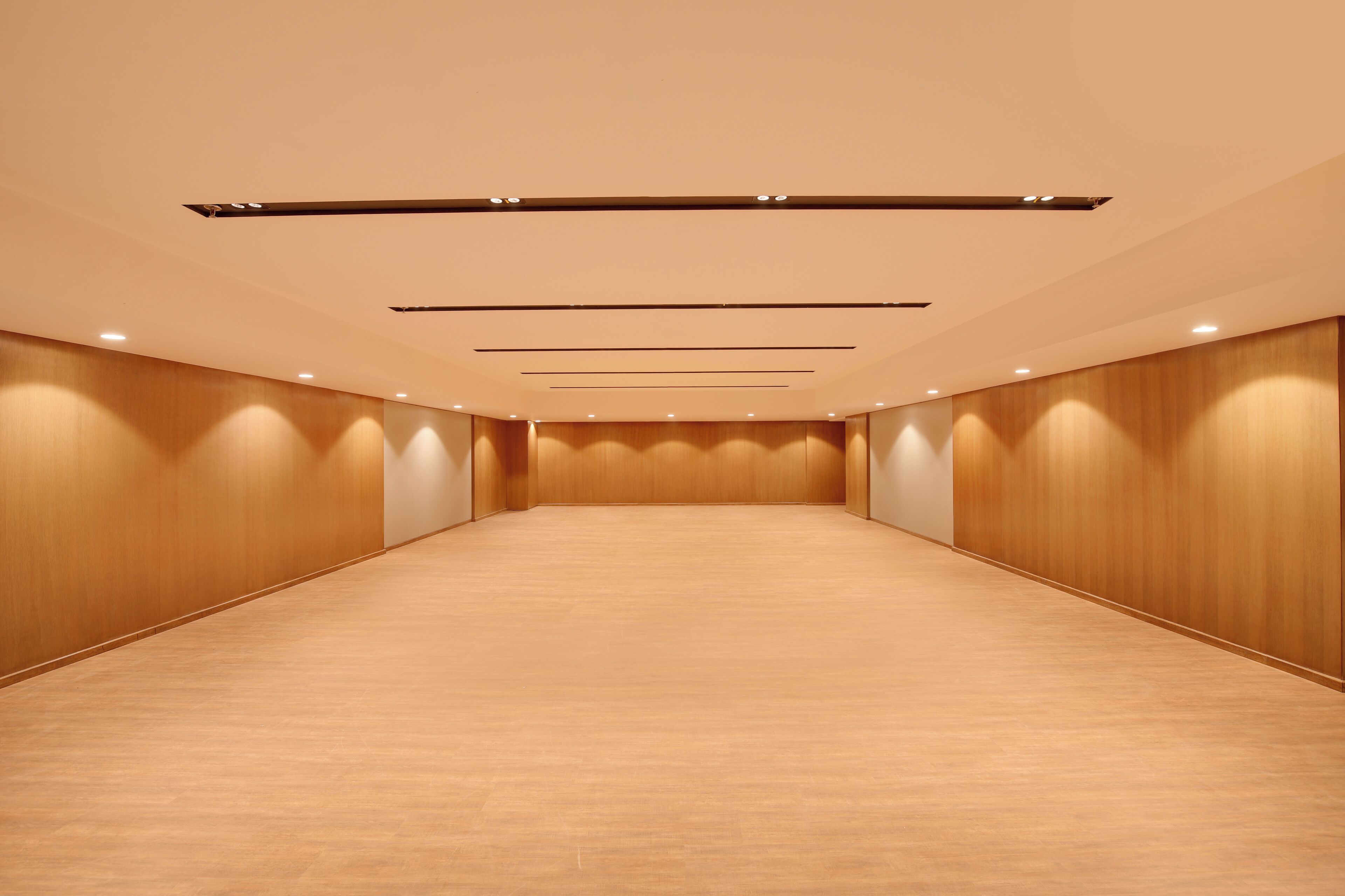 Ein geräumiger, gut beleuchteter Konferenzraum mit Holzvertäfelung und einem gl änzenden Boden.
