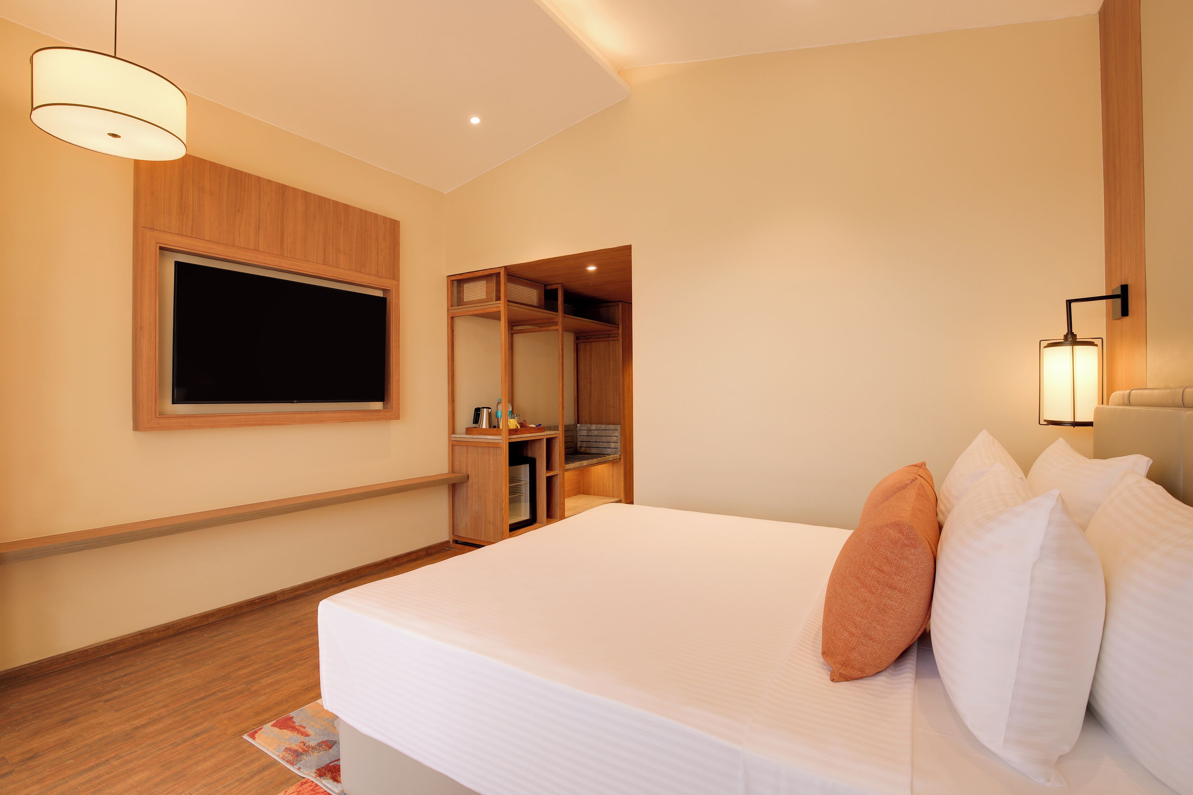 Ein Hotelzimmer mit einem großen Bett, einem Kleiderschrank, einem Spiegel und einem Fernseher.