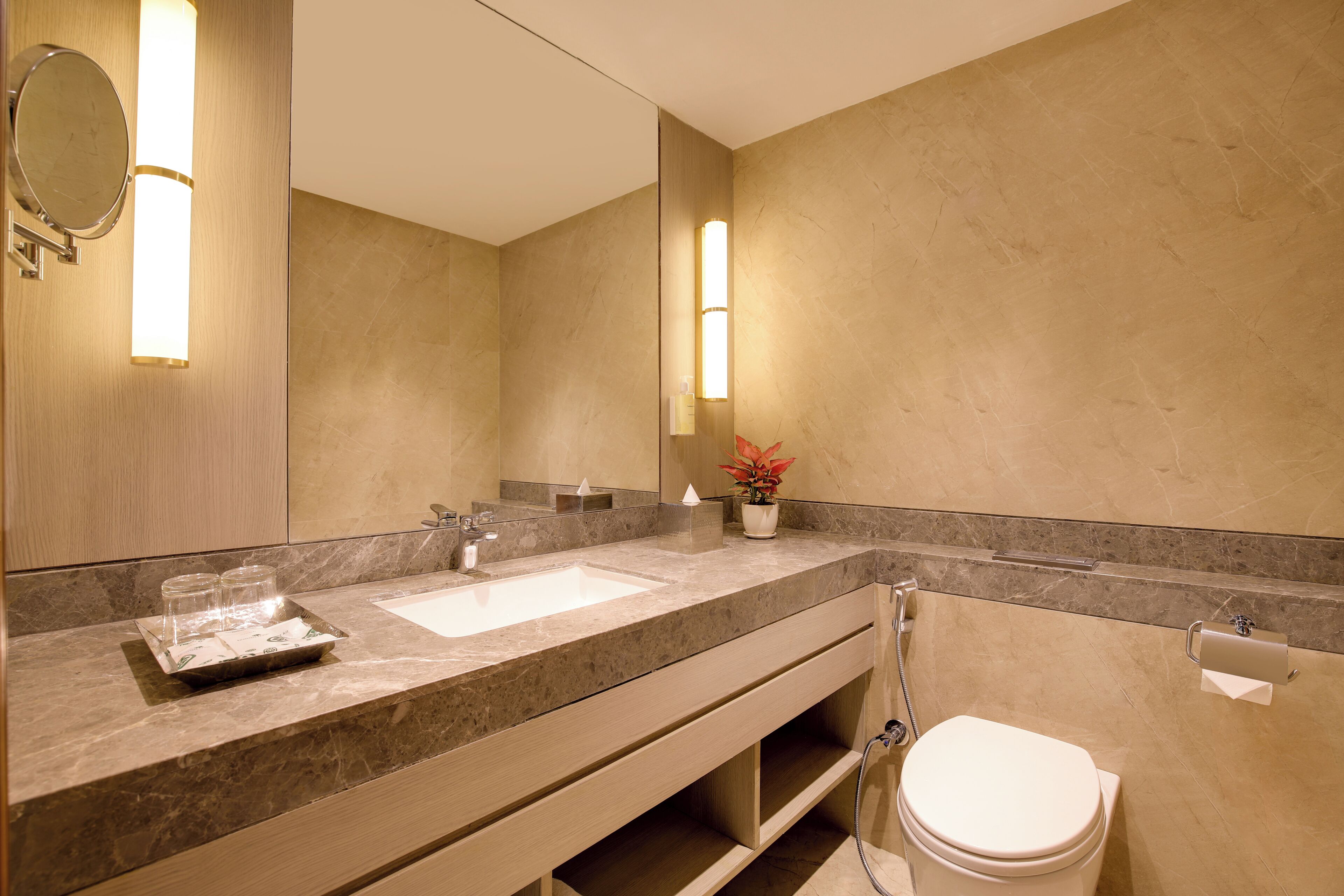 Un baño moderno con dos lavamanos, un espejo grande y un inodoro.