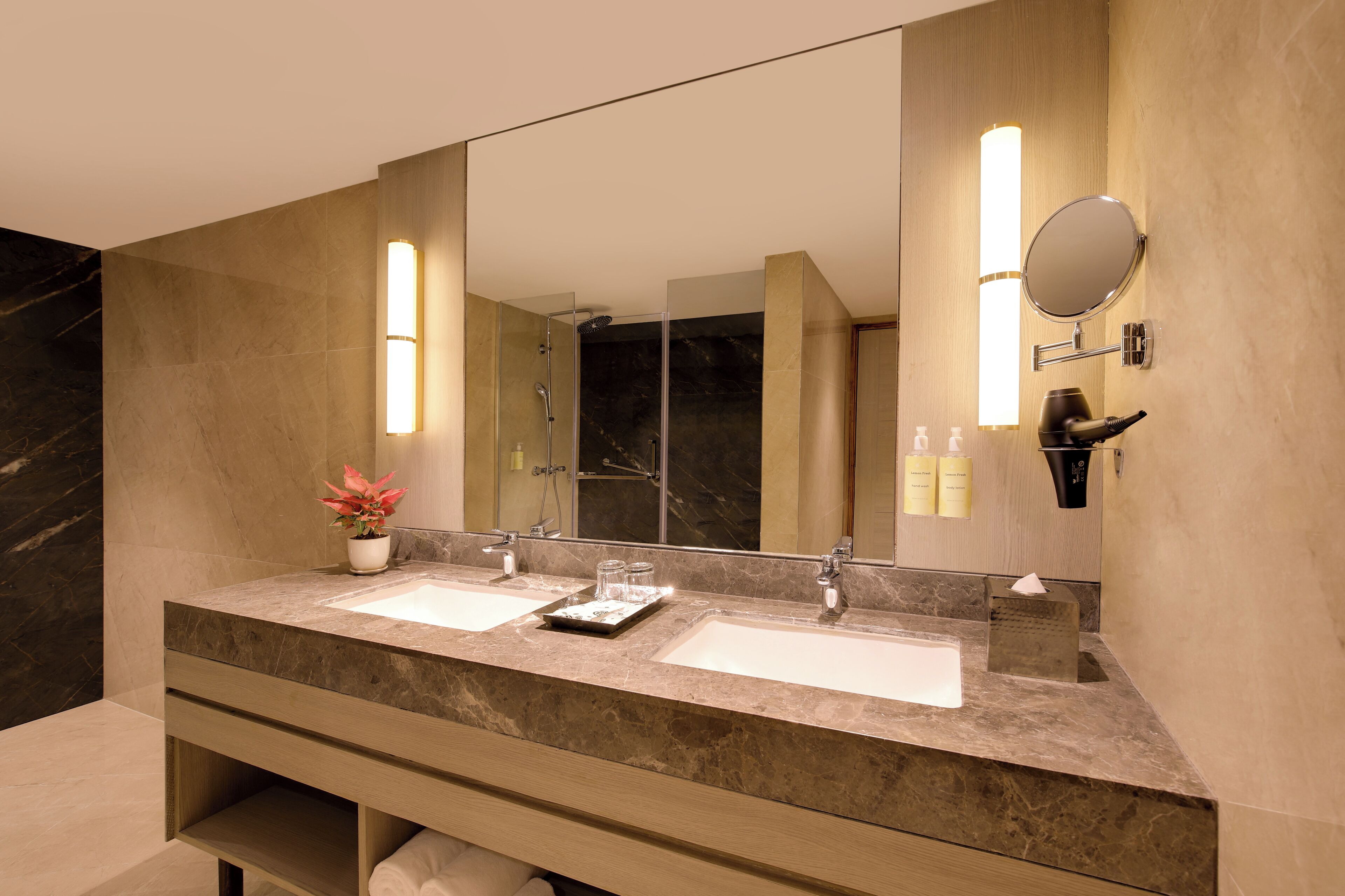 Een moderne badkamer met twee wastafels, een grote spiegel en een douche.
