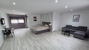 A modern bedroom with a bed, a sofa, a desk, and a chair. - Le 46 Cosy, modern villa.  Between Paris, Disneyland and Parc Asterix (Villiers-sur-Marne)