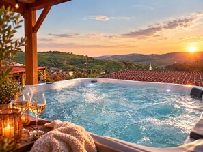 A hot tub with a view of a village and hills during sunset. - Tiny d'Monts (Brullioles)
