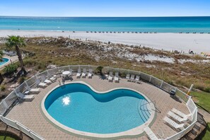 A swimming pool with a heart-shaped design, surrounded by lounge chairs and a deck area.