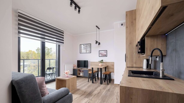 Ein moderner Wohnraum mit Sofa, Essbereich und Küche.
