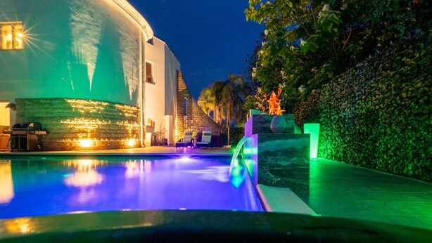 A swimming pool with a water feature, a dome-shaped building, and a well-maintained hedge. - Pink Moon Villa. Private Pool. Close to the Beach. 10 guests. Luxury. (Fontane Bianche)