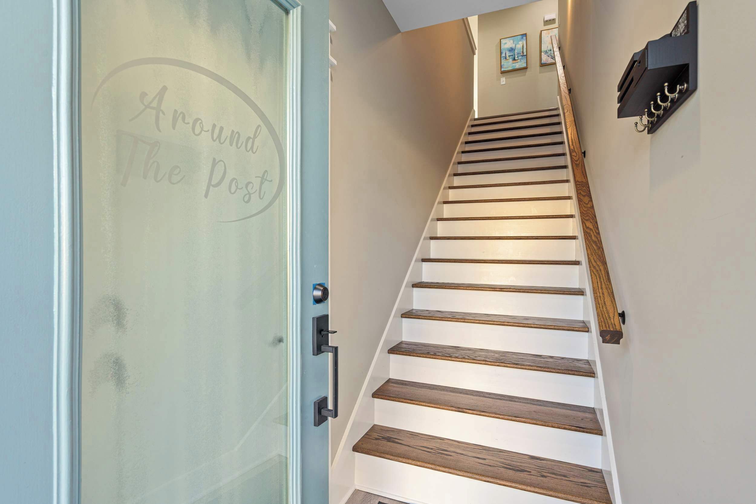 Una escalera con escalones de madera y una puerta de vidrio con panel esmerilado.