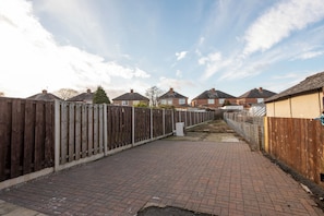 A paved pathway flanked by wooden fences leading to residential houses. - Toast Stays - Brankin Mill (Darlington)
