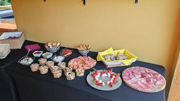 A table with various food items and condiments, including bread, cheese, and meats, arranged on a black tablecloth.