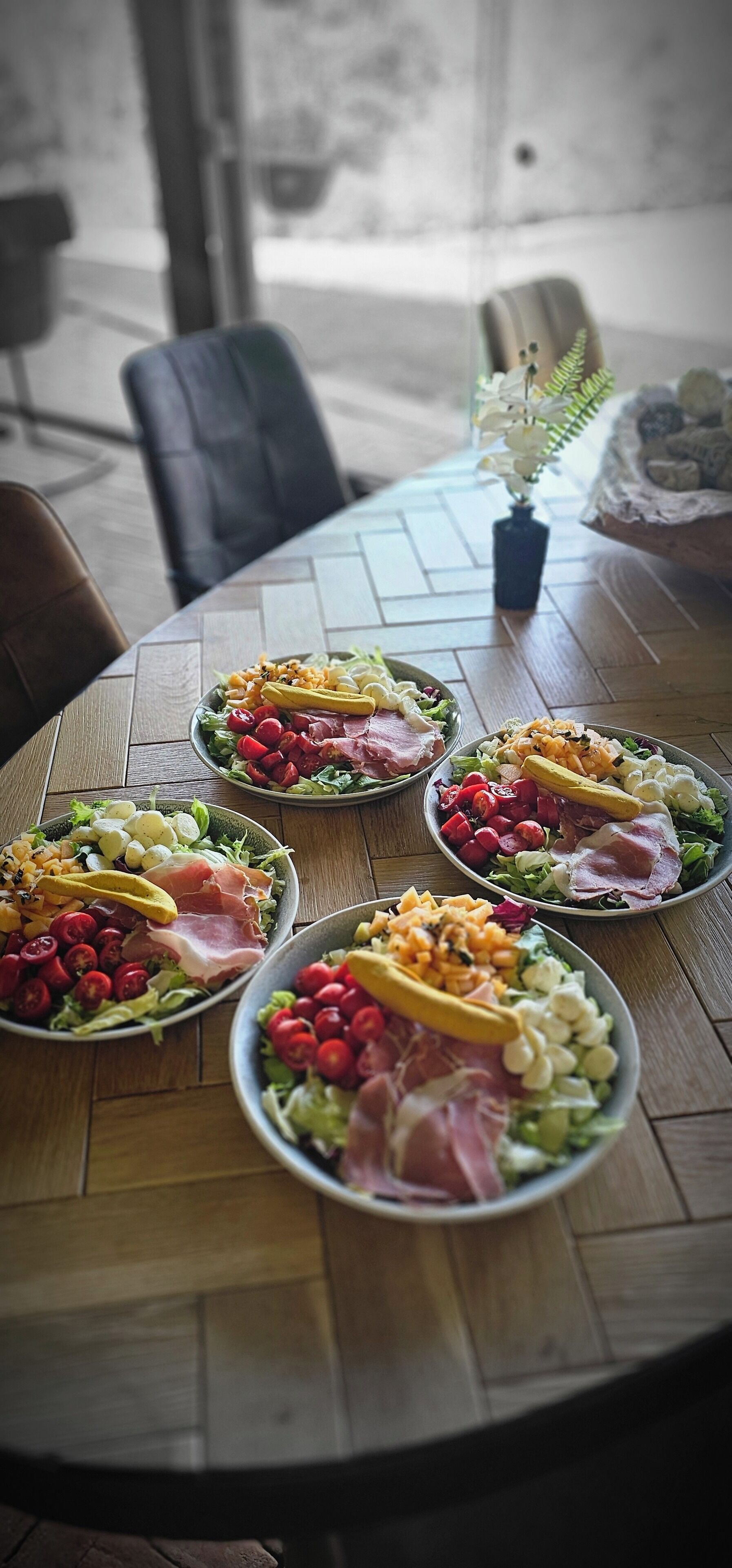A wooden table with five plates of assorted food items.