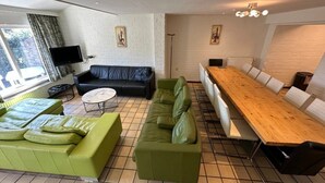 A modern living room with a sofa set, a coffee table, a TV, and a dining table.