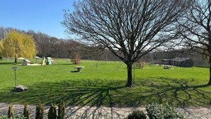 A park with a large tree, a picnic area, and a playground.