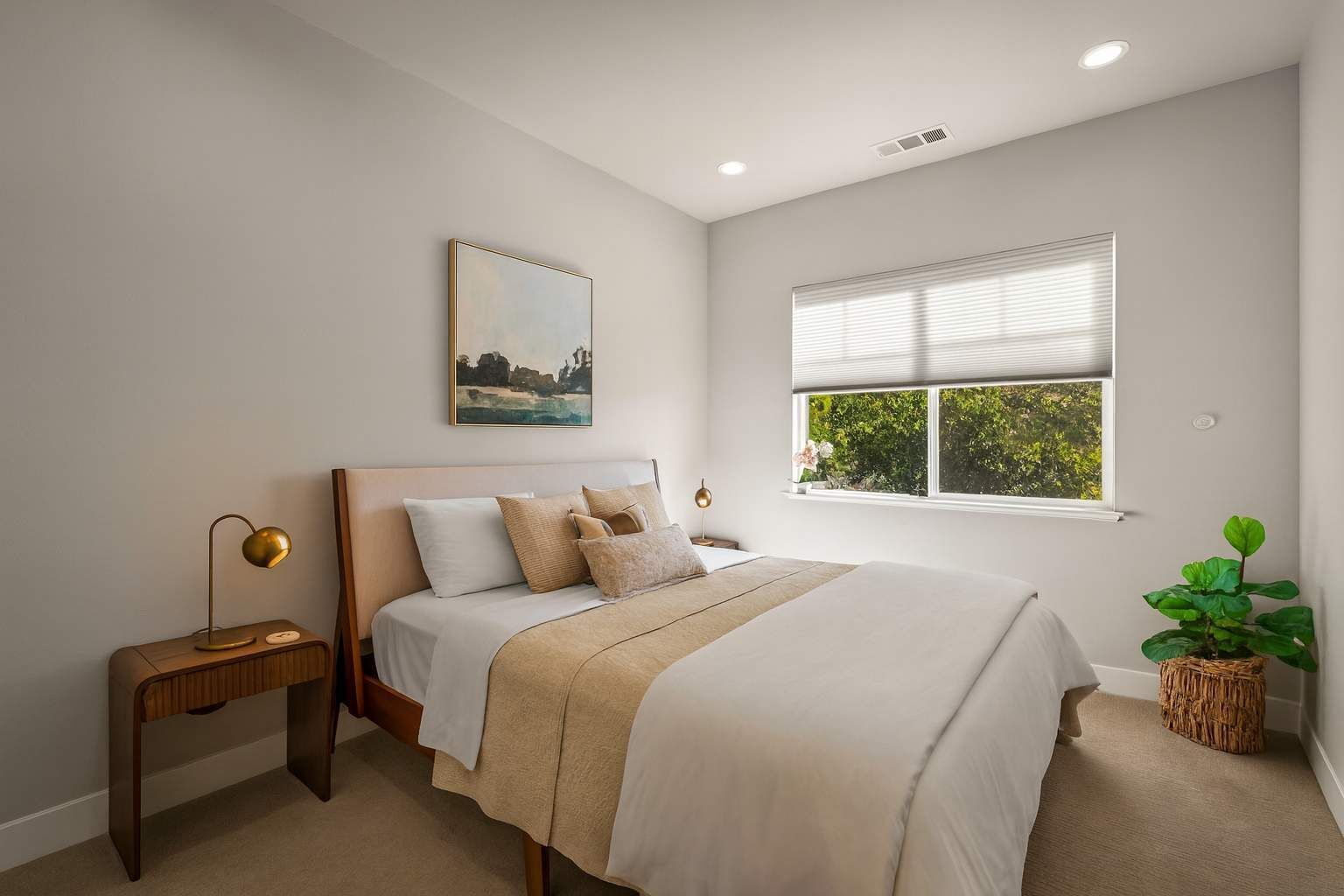 A bedroom with a bed, bedside tables, a window with blinds, a painting, and a potted plant.