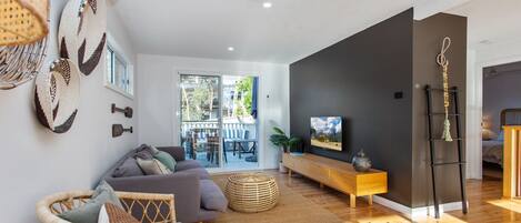 Un salon moderne avec un canapé, un téléviseur et un meuble en bois.