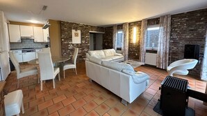 Un espace de vie compact comprenant une cuisine, un coin repas et un coin salon.