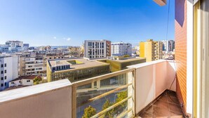 A high-rise building with a modern design, featuring a large glass balcony and a view of the cityscape. - Spacious Stay in the Heart of Tirana by PikHost (Tiranë)