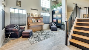 A spacious living room with a piano, a sofa, a rug, and a staircase. - Labor Day Weekend Special: Flexible Check-in/out! (Phoenix)