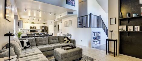 A modern living room with a sectional sofa, a coffee table, and a ceiling fan.