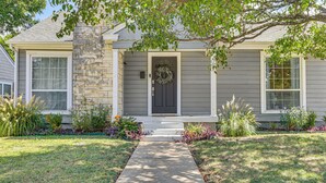 A house with a front porch, a stone pillar, and a door with a wreath. - 1 Mi to Smu: Home w/ Outdoor Entertainment (Dallas)